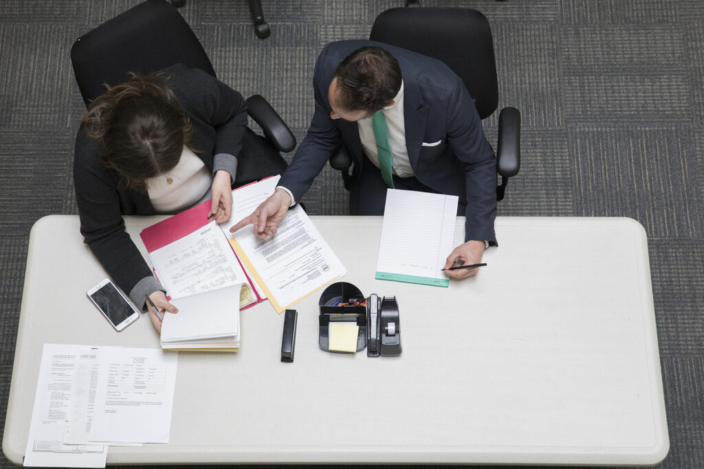 two people at a desk going over papers